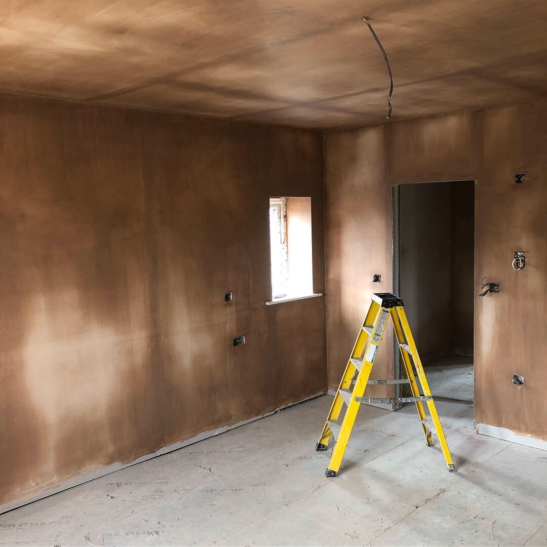 Room freshly plastered, with a yellow step ladder in the corner