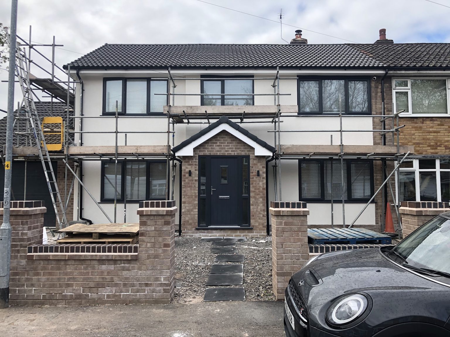 House front freshly rendered white with scaffolding still up