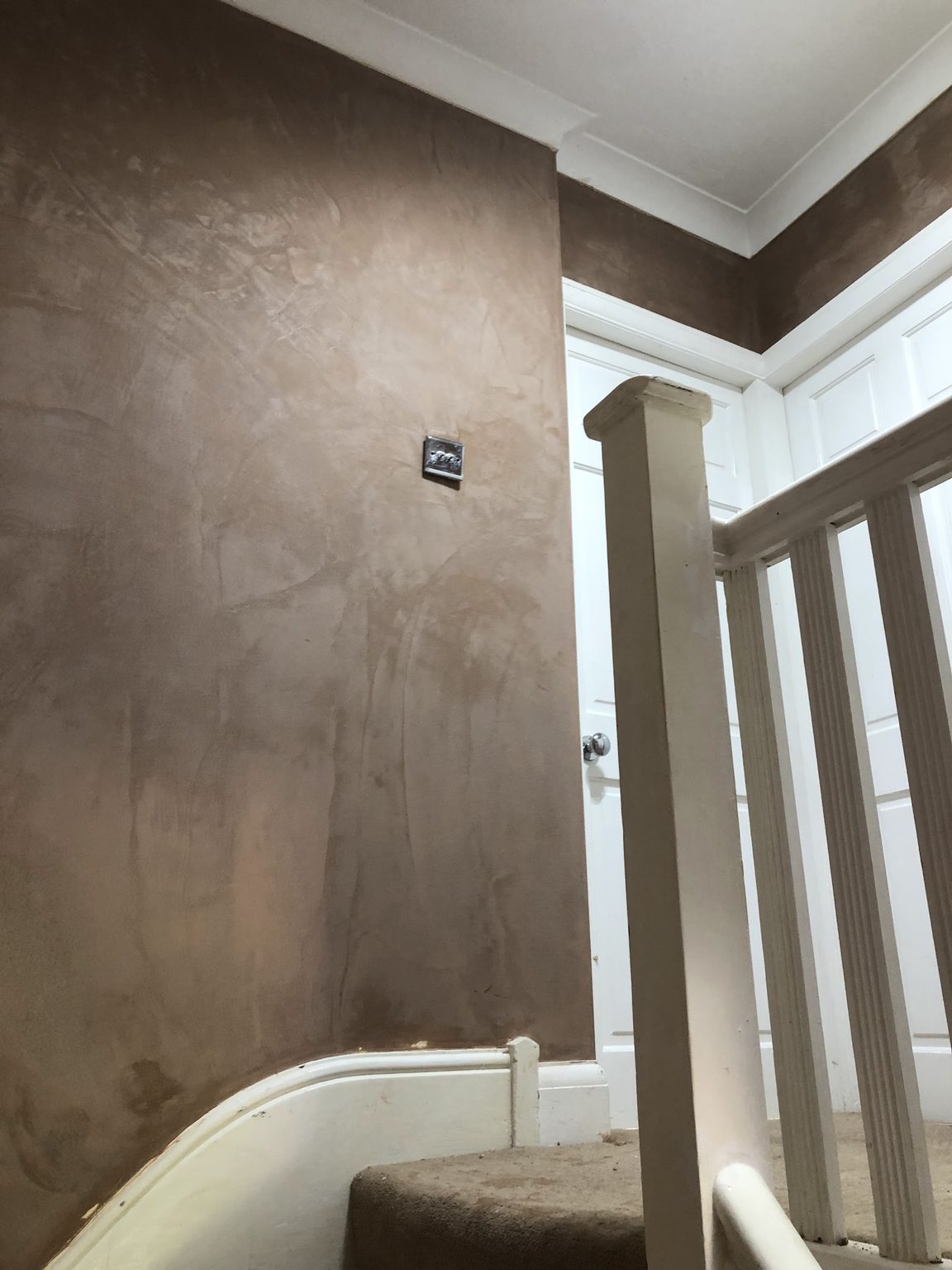 Fresh skim plaster drying on a stairwell wall