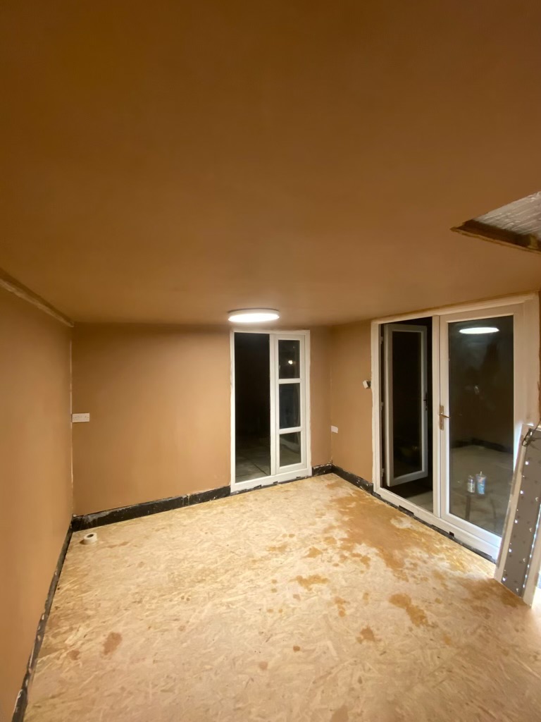 Plastered room with patio doors and a roof light